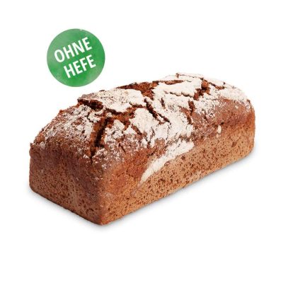 Ein dichter brauner Roggenvollkornbrotlaib, mit Mehl bestäubt und mit rissiger Oberfläche, trägt ein grünes rundes Etikett mit der Aufschrift „OHNE HEFE“, was bedeutet, dass es hefefrei ist. Das Brot ist vor einem weißen Hintergrund platziert.