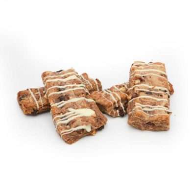 Ein Stapel rechteckiger Chocolate-Chip-Biscotti, mit weißem Zuckerguss beträufelt, auf einem weißen Hintergrund angeordnet.